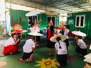 Young students rehearsing their dance with the parasols