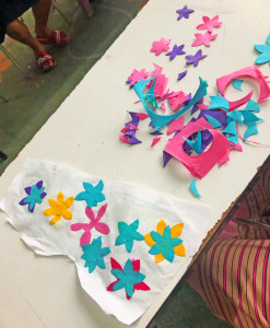 Students cut dyed mulberry paper into floral shapes to be appliquès onto the parasols.