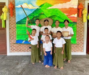 Some of the boys, wearing traditional Longyi (Myanmar Pants) in front of our mural before their performances.